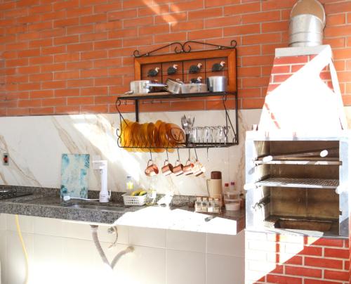 a kitchen with a counter and a brick wall at Maravilhosa Casa de Hóspedes in Boa Esperança