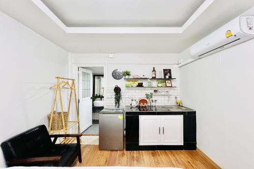 a kitchen with white walls and a black counter at Bann Kam B&B in Krabi town