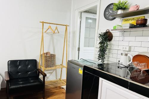 a kitchen with a black chair and a counter at Bann Kam B&B in Krabi town
