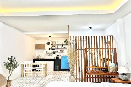 a living room with a kitchen with a table and chairs at Bann Kam B&B in Krabi town