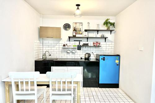 a kitchen with a table and a blue refrigerator at Bann Kam B&B in Krabi town