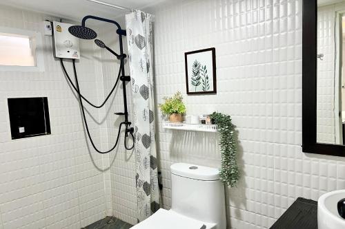 a white bathroom with a shower and a toilet at Bann Kam B&B in Krabi town