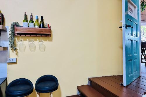 a room with two stools and wine bottles on a wall at Bann Kam B&B in Krabi town