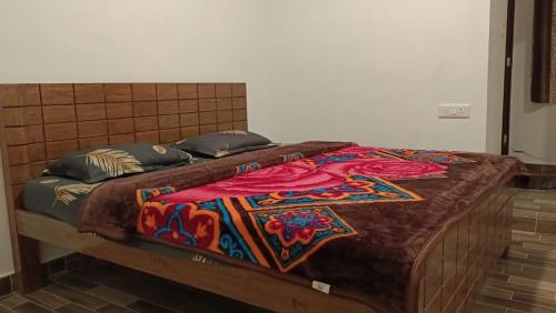 a bed with a colorful blanket on top of it at Kodai Castle in Kodaikānāl