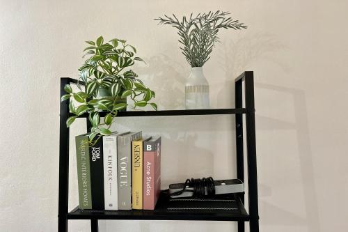 a book shelf with books and plants on it at Bann Kam B&B in Krabi town