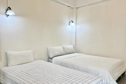 two beds sitting next to each other in a room at Bann Kam B&B in Krabi town