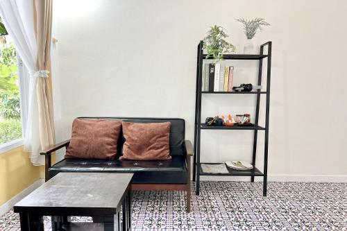 a living room with a couch and a book shelf at Bann Kam B&B in Krabi town