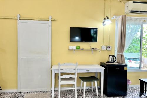 a room with a desk and a tv on a wall at Bann Kam B&B in Krabi town