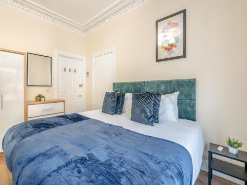 a bedroom with a large bed with a blue blanket at Apartment Four - Uk44287 in Arbroath
