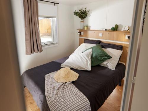 a bed with a hat on it in a room at Mobil-home avec terrasse pour 4 personnes - API-1-52-528 in Le Boulou