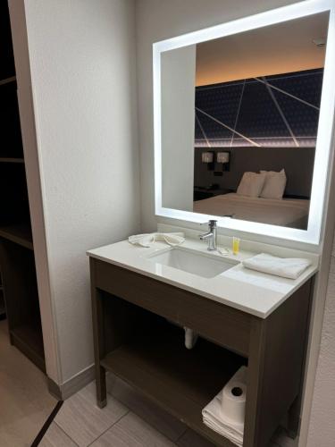 a bathroom with a sink and a mirror at Comfort Inn & Suites Harvey - Chicago Southland in Harvey