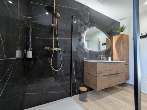 ein Badezimmer mit Dusche, Waschbecken und Spiegel in der Unterkunft Maison de vacances raffinée avec terrasse et piscine partagée - FR-1-589-837 in Dounoux