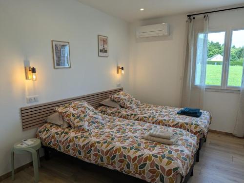 ein Schlafzimmer mit zwei Betten und einem Fenster in der Unterkunft Maison de vacances raffinée avec terrasse et piscine partagée - FR-1-589-837 in Dounoux