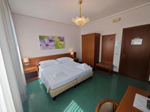 a bedroom with a bed and a table and a chandelier at Casa Malvina in Mira