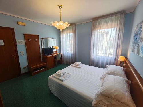 a bedroom with a large bed and a chandelier at Casa Malvina in Mira