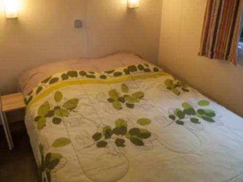 a bed in a room with a blanket on it at Mobile-home 6 pers avec terrasse à Naucelle - API-1-52-415 in Naucelle