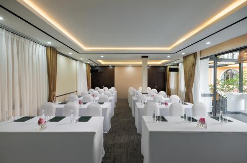 a conference room with white tables and white chairs at Sen Village Hoi An in Hoi An