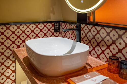 a white sink on a counter in a bathroom at Super Time Trendy Design Hotel Guangzhou Beijing Road Pedestrian Street Dafo Temple Branch in Guangzhou
