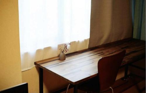 a wooden table in a room with a window at 北のくらし研究所 in Rokugō
