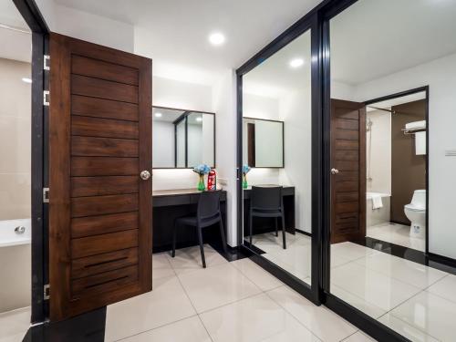 a bathroom with a vanity and a desk with a mirror at Samutprakarn Hotel in Samut Prakan