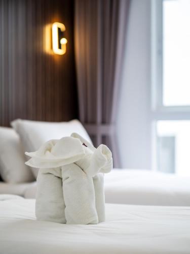 a stuffed elephant sitting on top of a bed at Samutprakarn Hotel in Samut Prakan