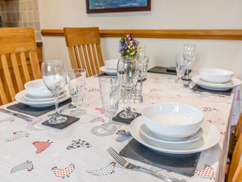 a table with plates and glasses on top of it at The Lodge in Lydney