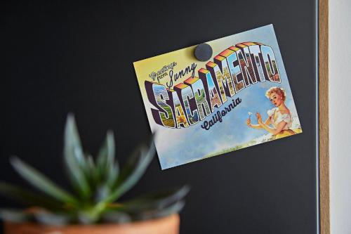 a sign on a wall next to a plant at Kimpton Sawyer Hotel by IHG in Sacramento