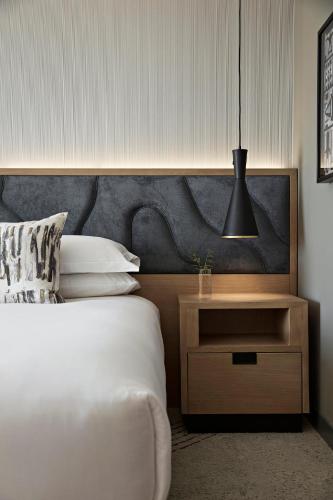a bedroom with a bed and a nightstand and a lamp at Kimpton Sawyer Hotel by IHG in Sacramento