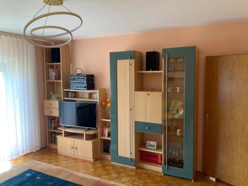 a living room with a tv and some shelves at Freistehendes Ferienhaus Mit Südbalkon in Marktrodach