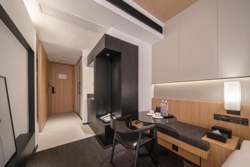 a small room with a table and a chair at Hill Design Hotel 山丘设计师酒店 春熙路太古里店 in Chengdu