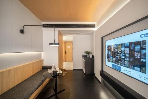 a living room with a large tv and a table at Hill Design Hotel 山丘设计师酒店 春熙路太古里店 in Chengdu