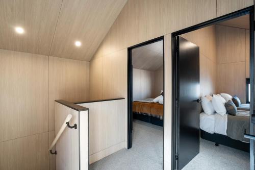 a room with two beds and a mirror at Apres Peak - Queenstown Holiday Home in Frankton Wharf