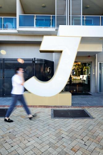 a person walking past a large letter k sculpture at Jephson Hotel & Apartments in Brisbane