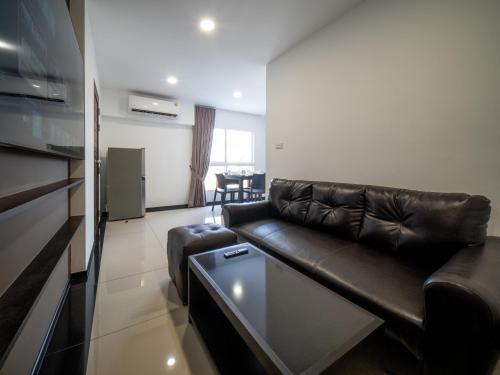 a living room with a leather couch and a table at Samutprakarn Hotel in Samut Prakan