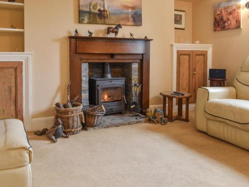 a living room with a fireplace and a couch at Yew Tree Cottage in Old Brampton