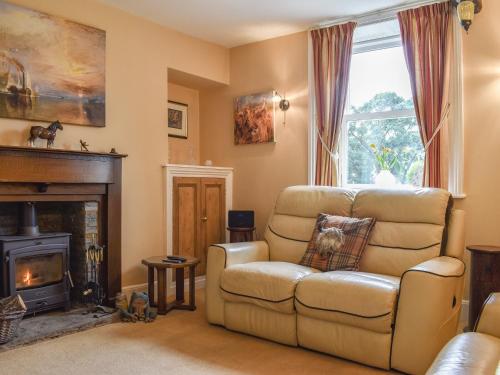 a living room with a couch and a fireplace at Yew Tree Cottage in Old Brampton