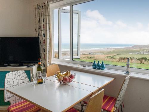 a dining room table with a view of the ocean at Zephyr's View in Poundstock