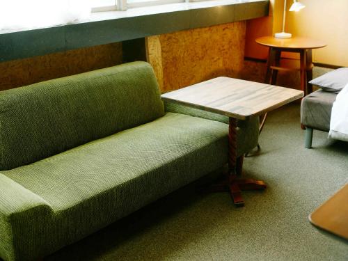 a green couch and a table in a room at 北のくらし研究所 in Rokugō
