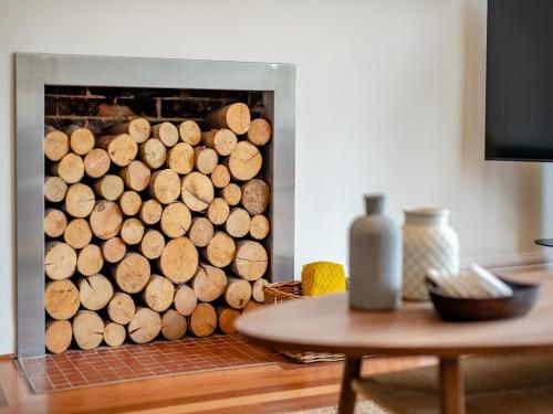 a fireplace filled with wood logs next to a table at Number 3 in Bournemouth