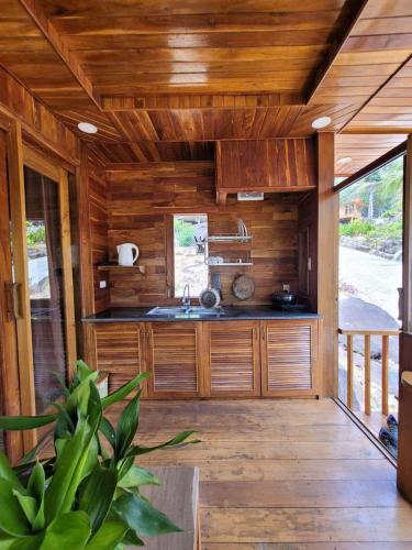 uma cozinha com paredes de madeira e piso de madeira em Jade Mountain Bungalow - Sea Breeze - Infinity Pool em Duong Dong
