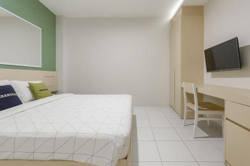 a bedroom with a bed and a desk and a television at Urbanview Syariah Oemah Isun Homestay Cirebon by RedDoorz in Tangkil
