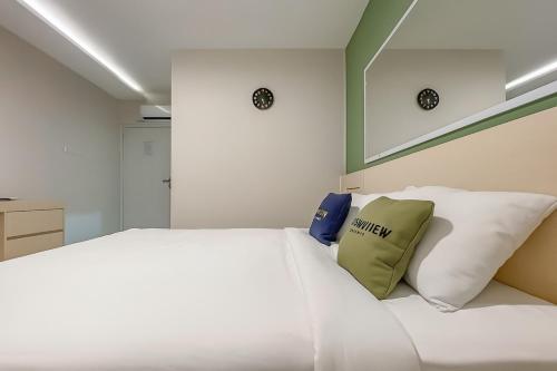 a bedroom with a white bed with two pillows at Urbanview Syariah Oemah Isun Homestay Cirebon by RedDoorz in Tangkil