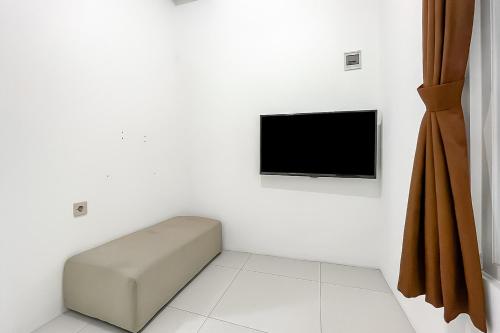 a white room with a television on a white wall at Urbanview Syariah Oemah Isun Homestay Cirebon by RedDoorz in Tangkil