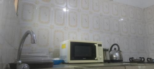 a microwave oven sitting on a counter in a kitchen at Comfort Zone Furnished Apartments 2 in Freetown