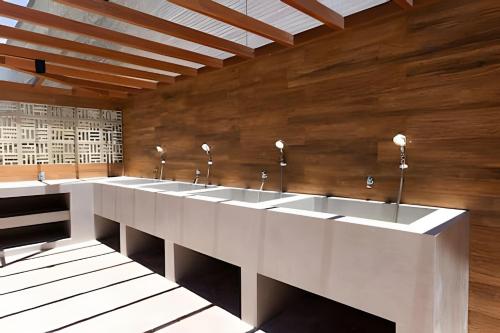 a row of sinks in a public restroom at ART STUDIO VISTA Mar FRONTAL ARMAÇAO PITUBA in Salvador