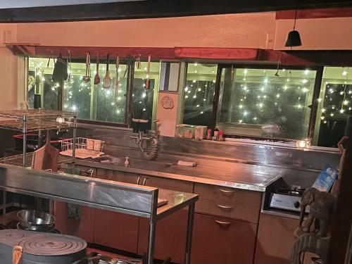 a kitchen with a counter and some windows at KOMINKA guest house in Omachi
