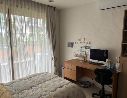 a bedroom with a bed and a desk with a computer at Playa Hua Hin 3BR Oceanfront in Khao Tao