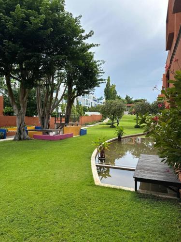 a park with a bench and a pond and trees at Playa Hua Hin 3BR Oceanfront in Khao Tao