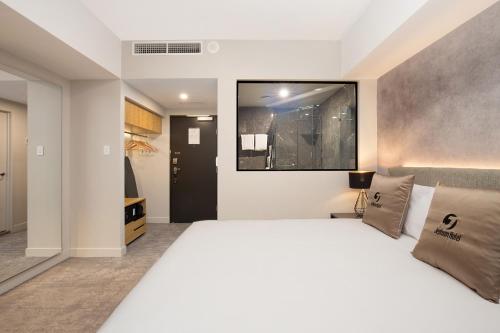 a bedroom with a large white bed in a room at Jephson Hotel & Apartments in Brisbane