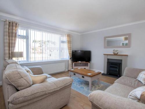 a living room with two couches and a tv at Raasay in Dornoch